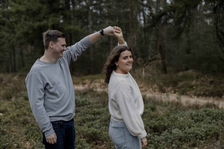 Een stralend koppel geniet van een loveshoot in Apeldoorn, waarbij ze door middel van opdrachtjes oprechte momenten beleven en samen lachen voor de camera.