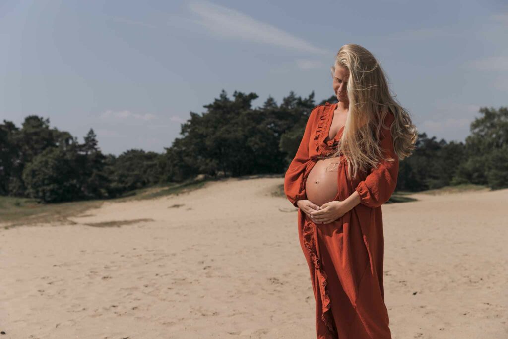 Zwangerschap fotoshoot in Apeldoorn, spontaan en ontspannen moment met partner in een natuurlijke omgeving.