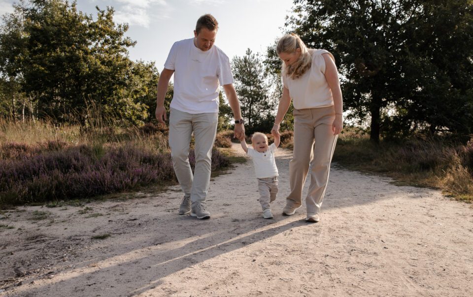 Gezin tijdens fotoshoot op bloeiende paarse heide bij Het Leesten in Apeldoorn – spontane en betaalbare minishoot op de Veluwe in de zomer