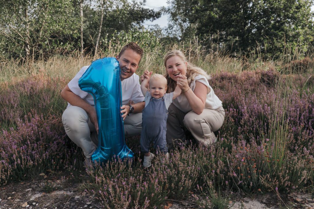 Gezin tijdens fotoshoot op bloeiende paarse heide bij Het Leesten in Apeldoorn – spontane en betaalbare minishoot op de Veluwe in de zomer