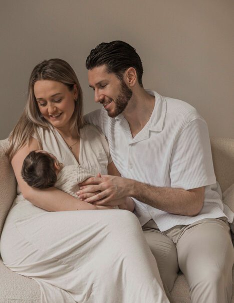 Newbornfotograaf Apeldoorn – vader en moeder knuffelen met pasgeboren dochter
