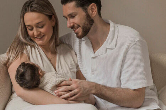 Newbornfotograaf Apeldoorn – vader en moeder knuffelen met pasgeboren dochter