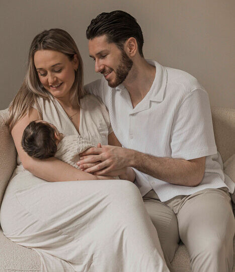 Newbornfotograaf Apeldoorn – vader en moeder knuffelen met pasgeboren dochter
