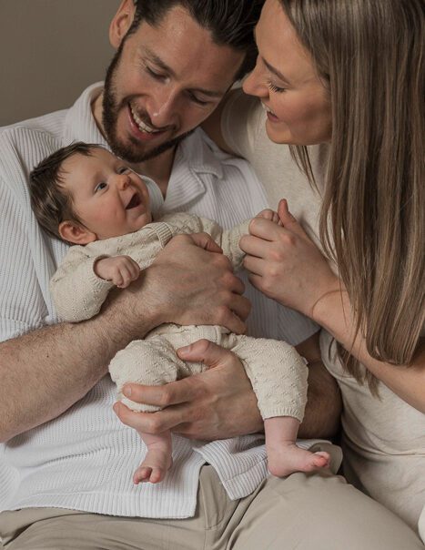 Newbornfotograaf Apeldoorn – vader en moeder knuffelen met pasgeboren dochter
