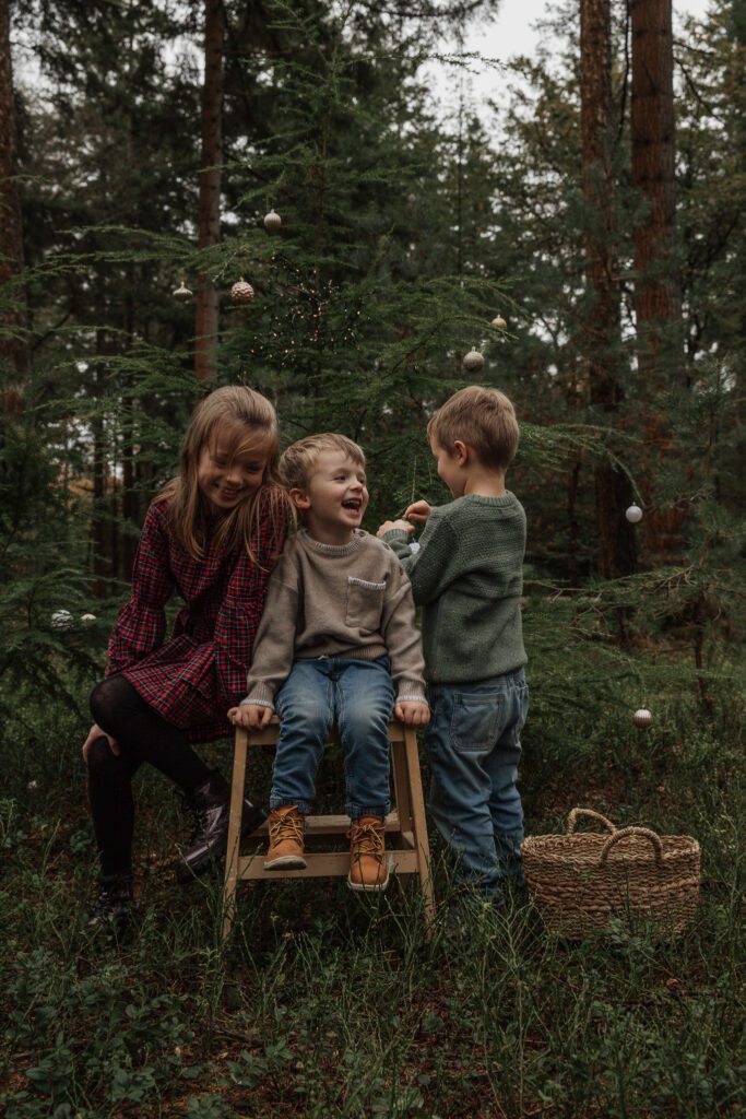 Kinderen versieren mini kerstboom tijdens kerstshoot Veluwe