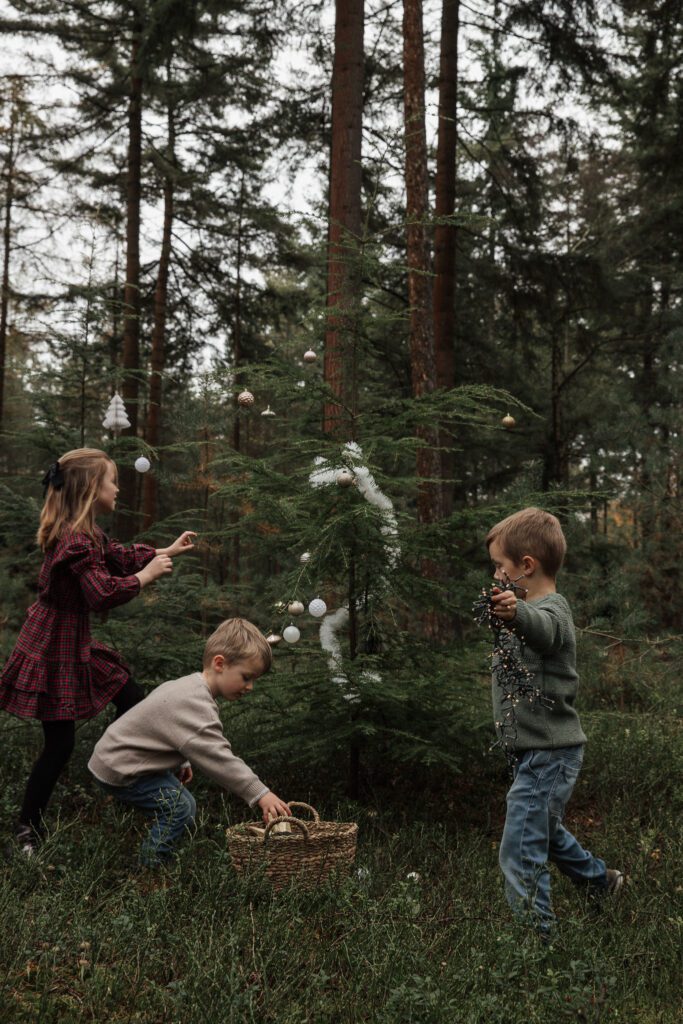 Kinderen versieren mini kerstboom tijdens kerstshoot Veluwe