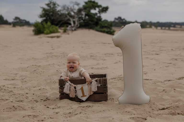 1 jaar shoot in Apeldoorn van een vrolijk kindje, liefdevolle fotosessie bij ouders thuis door een fotograaf die goed is met kinderen in Gelderland.