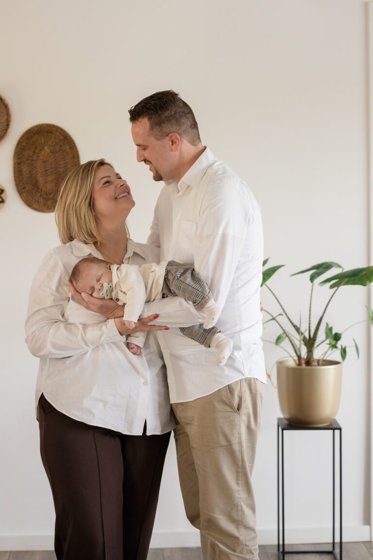 Liefdevolle moment tussen ouders en baby tijdens newbornshoot