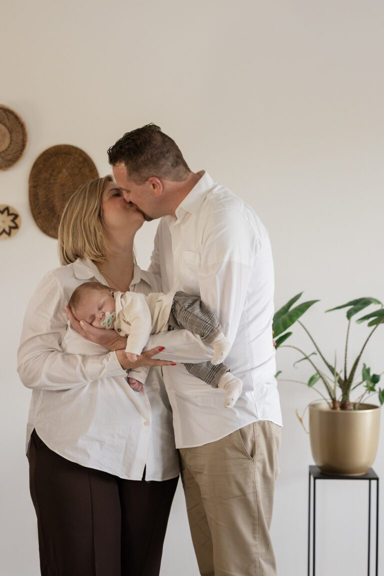 Liefdevolle moment tussen ouders en baby tijdens newbornshoot