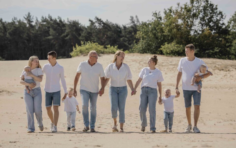 Familie Oosterhof tijdens een spontane familieshoot met drie generaties op het Kootwijkerzand bij Apeldoorn.