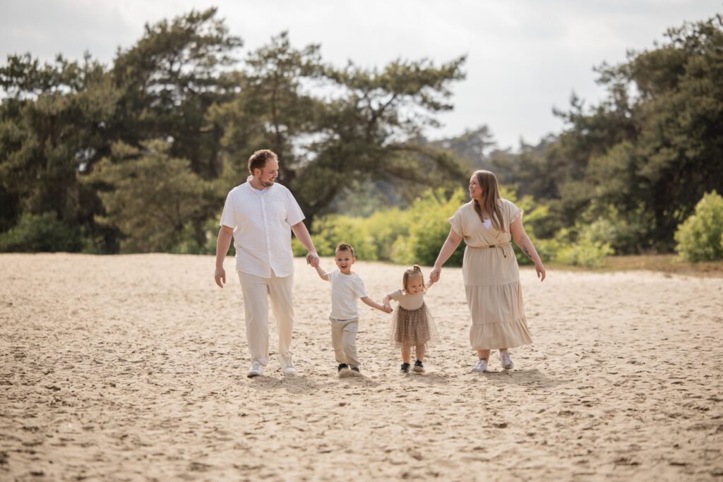 Gezinsshoot op Kootwijkerduin met jonge kinderen waarbij het gezin samen speelt en geniet tijdens een spontane fotoshoot op de Veluwe.