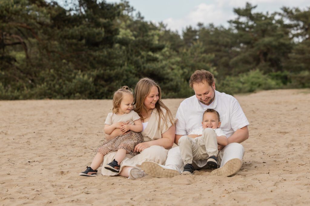 Gezinsshoot op Kootwijkerduin met jonge kinderen waarbij het gezin samen speelt en geniet tijdens een spontane fotoshoot op de Veluwe.