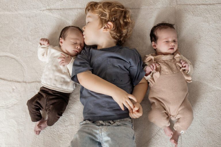 Grote broer op foto met kleine pas geboren baby's